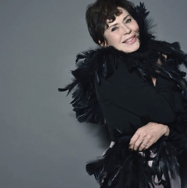 Ritratto in studio con mantella di piume nere.